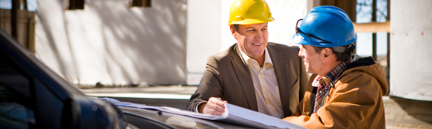 two men in construction hats talking